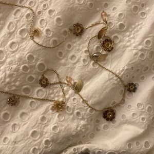 Long gold necklace with floral jewels